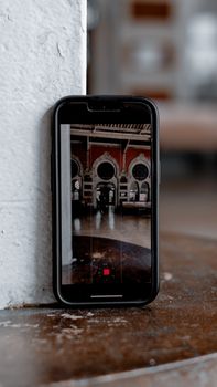A smartphone captures the interior of a historic building with round windows.