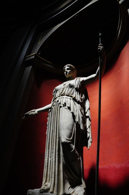 Striking image of an ancient Greek statue illuminated by dramatic lighting in a museum gallery.