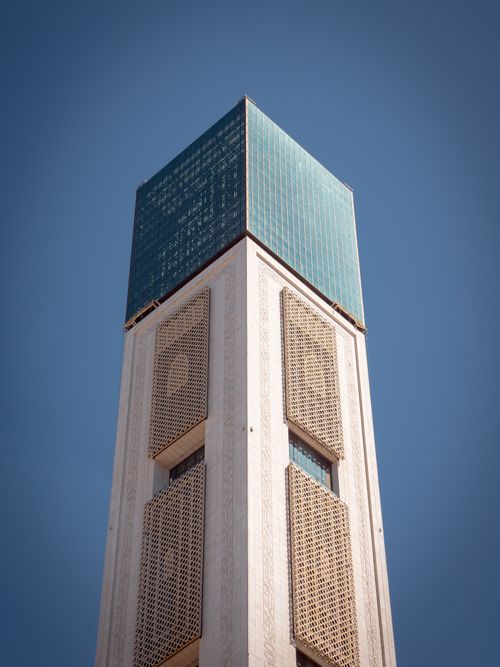 Free A towering skyscraper blending modern glass and traditional patterns under a clear sky. Stock Photo