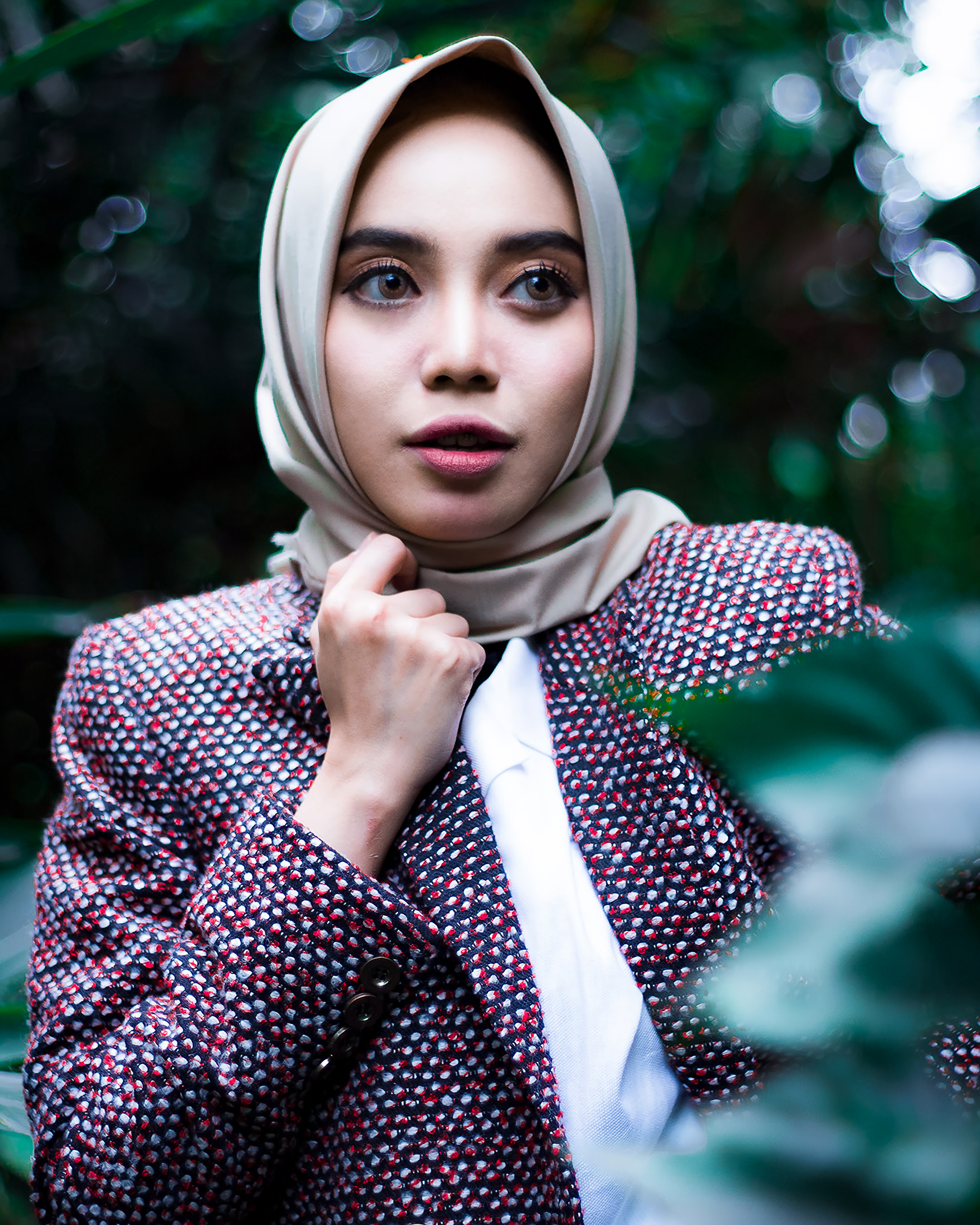 Stylish portrait of a woman in a hijab outdoors, showcasing elegance and fashion in a natural setting.