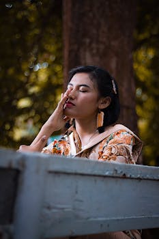 一位时尚女性闭目静坐于户外，沉浸在大自然的宁静之中