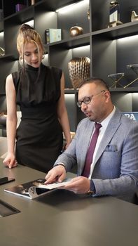 Two professionals engaged in a meeting at a stylish office desk in Ankara.
