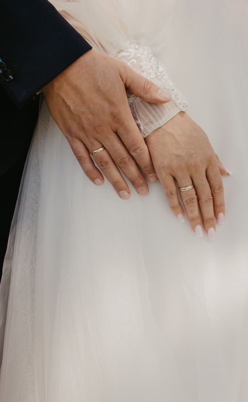 Free Close-up of bride and groom's hands with wedding rings, symbolizing love and commitment. Stock Photo