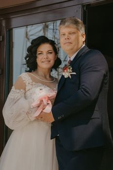 Bride and groom sharing a joyful moment, embracing with a bouquet.