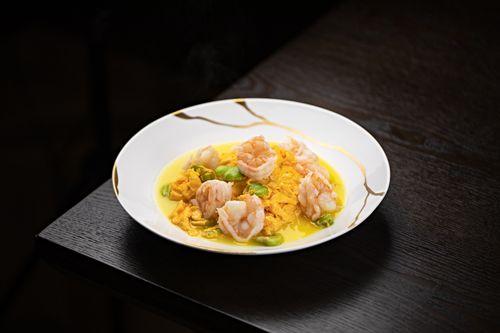 Free Delicious shrimp curry served on an elegant white plate with a dark wood table backdrop. Stock Photo