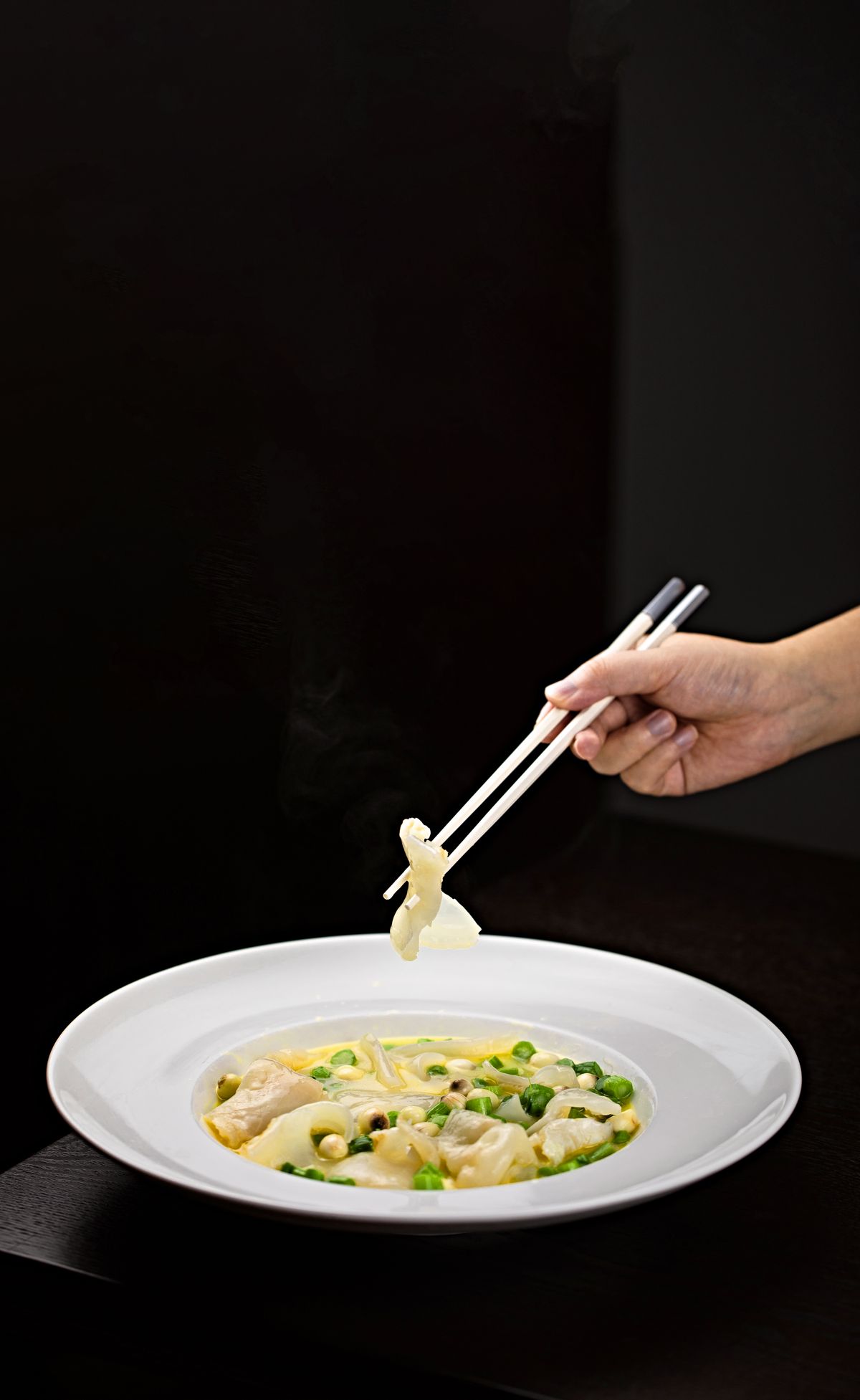 Kom dumplingsoep met dumplings en bosui