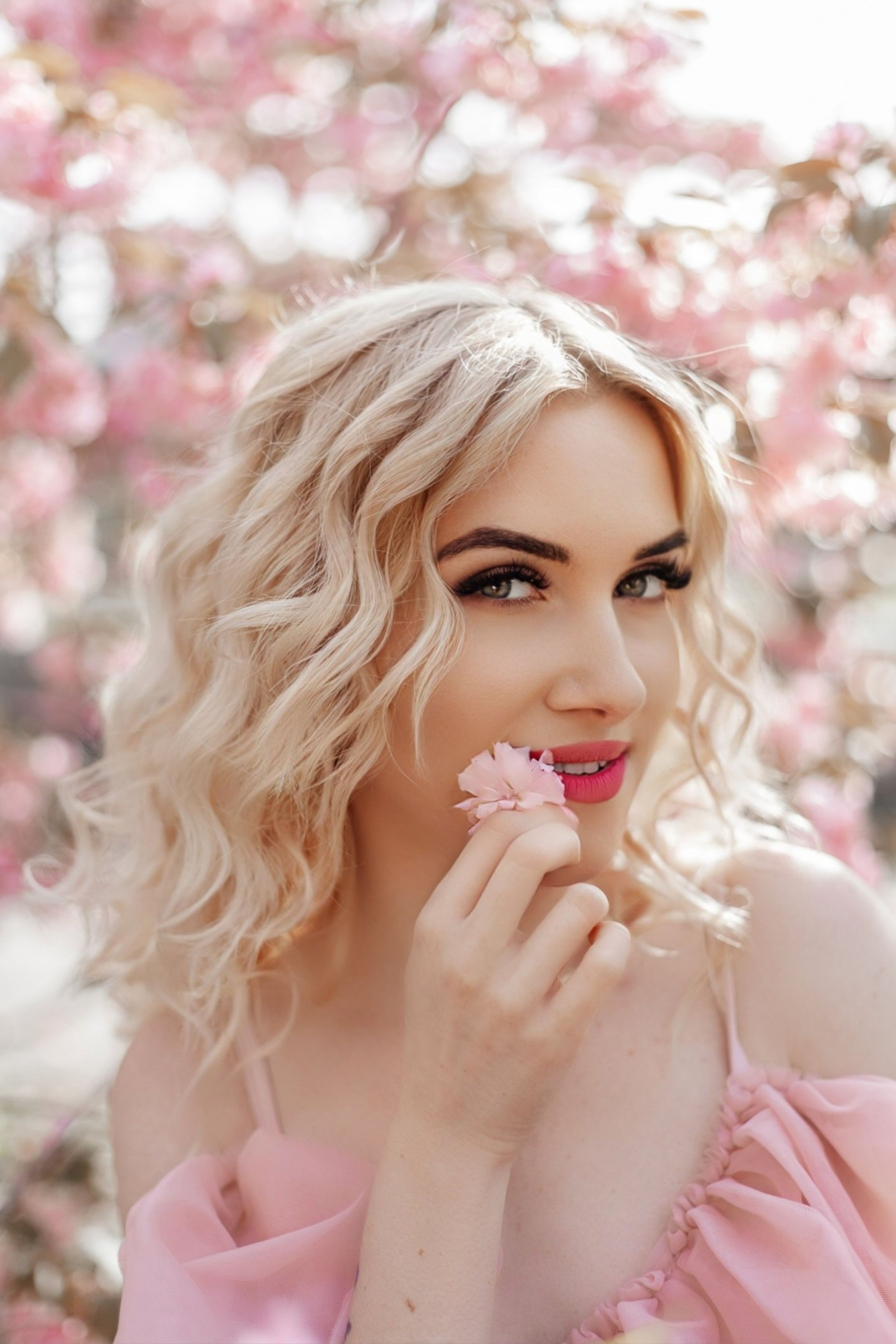 Portrait of a Young Woman Standing in a Park and Holding a Pink Flower ...