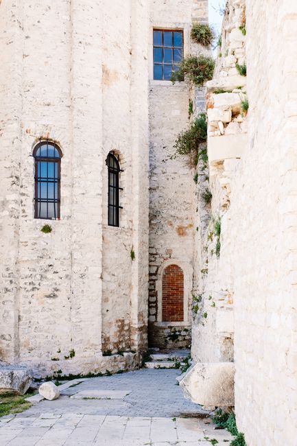 Charming stone alleyway amidst ancient architecture in Old Town Zadar, Croatia.