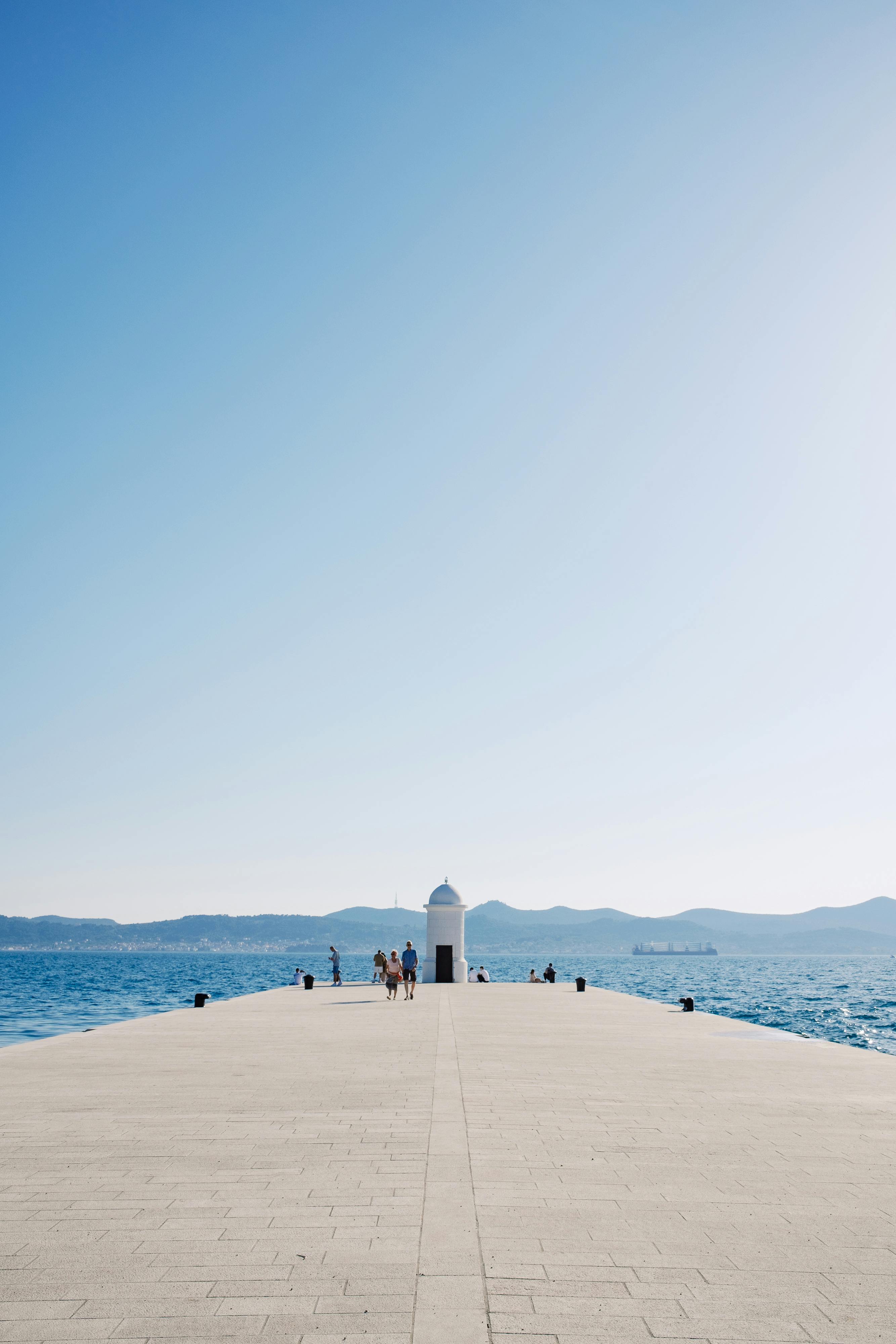 a person walking on a pier in front of the ocean