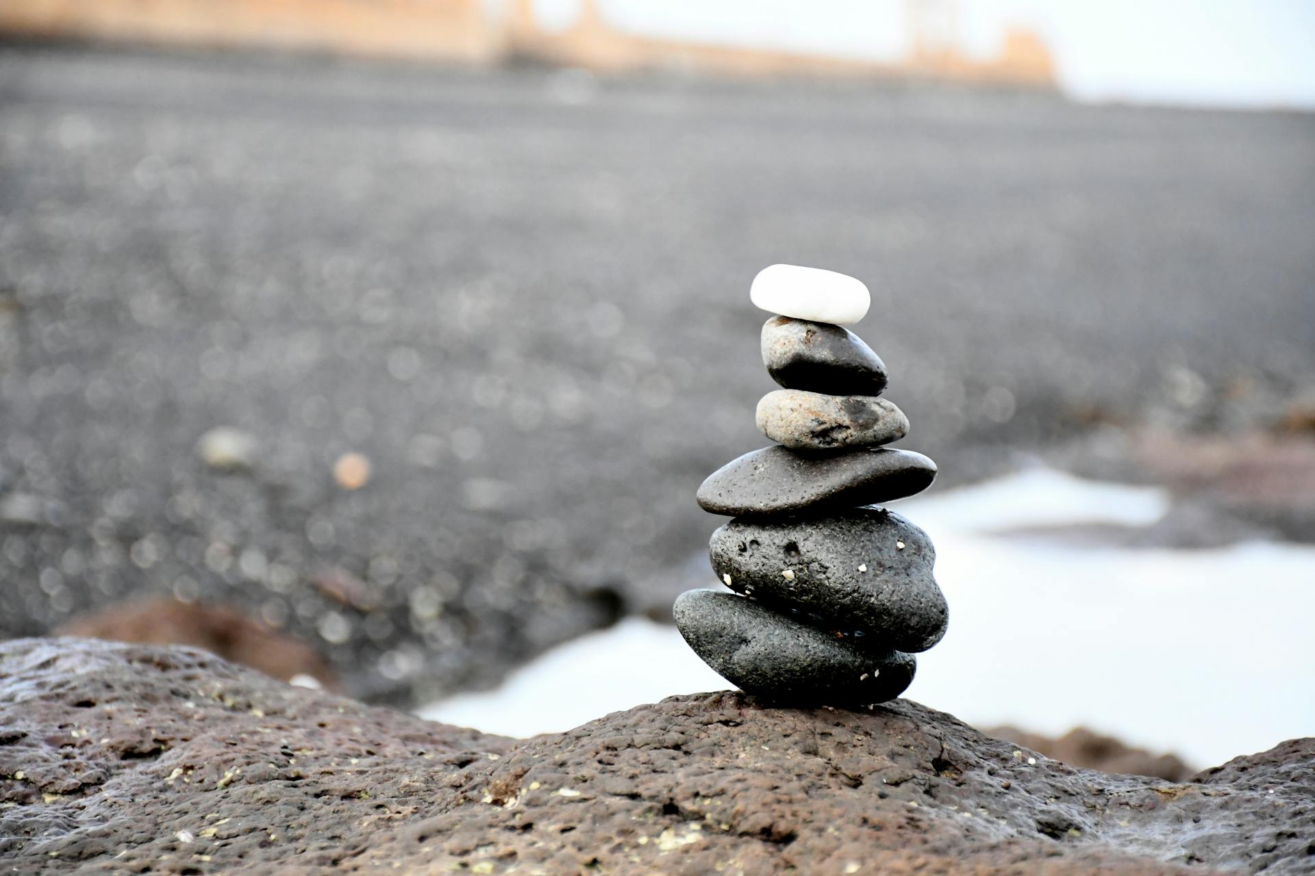 Peaceful beach scene featuring a stack of smooth stones, symbolizing balance and tranquility.