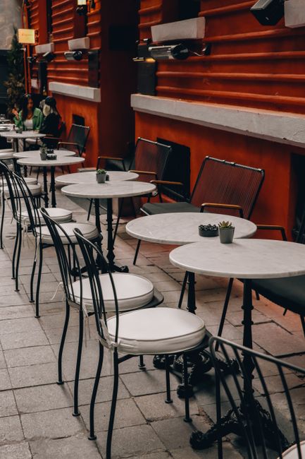 Outdoor cafe with elegant metal and marble tables and chairs in Istanbul, Türkiye.
