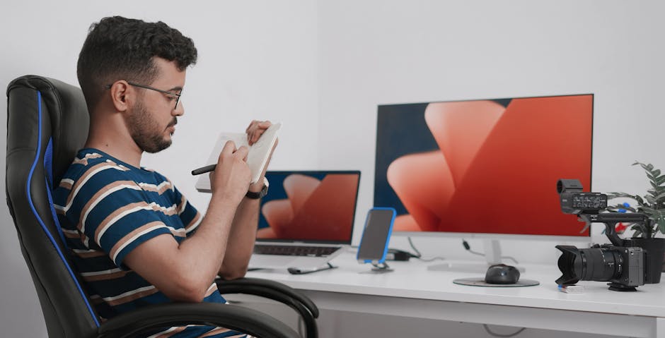 How Video Baby Monitors Improve SIDS Risk Awareness for New Parents Young man taking notes at a modern desk with electronics and camera equipment in Nouakchott.