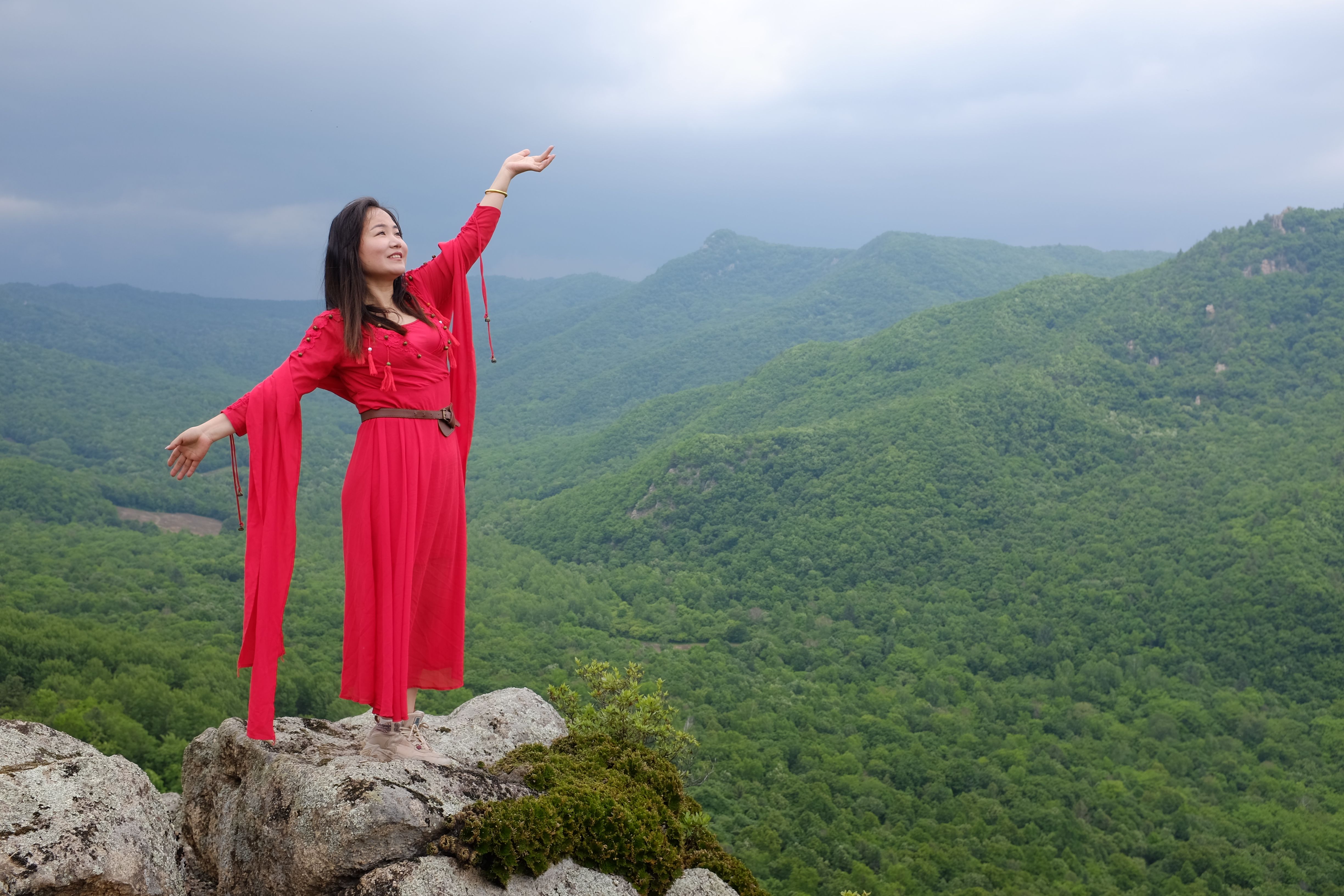 Woman in Dress Standing on Rock on Hilltop over Forest · Free Stock Photo
