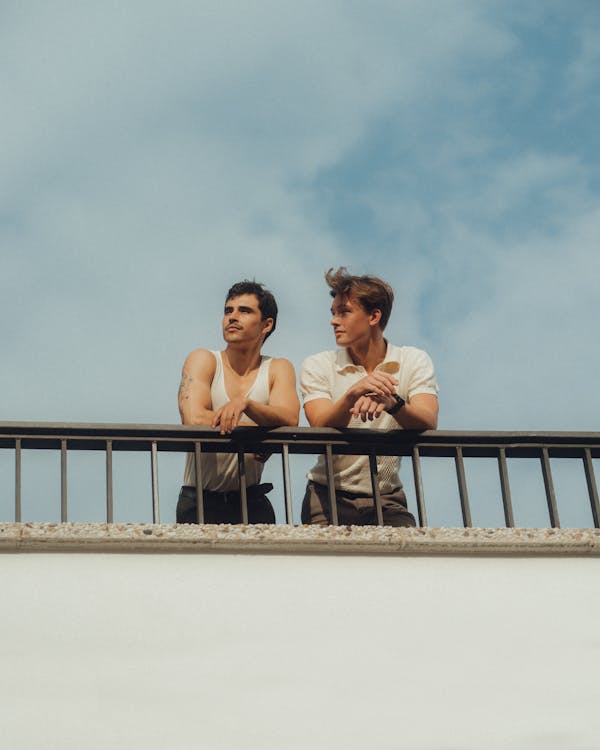 Men in Casual Clothing Leaning against Railing · Free Stock Photo