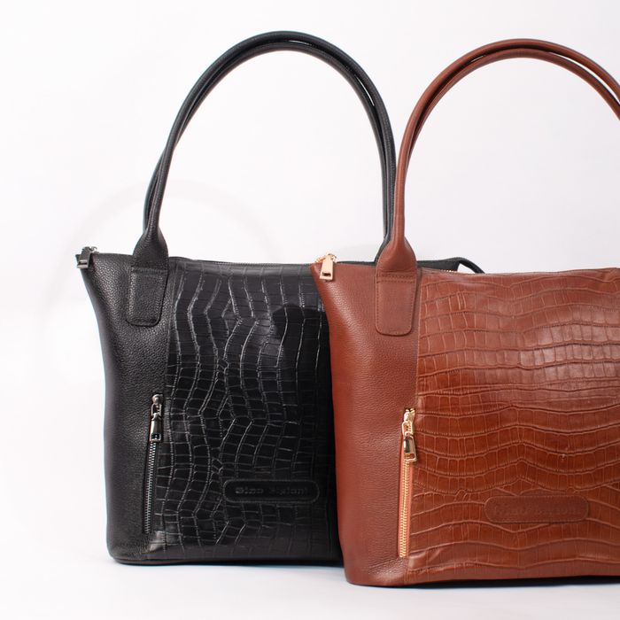 Black and tan leather holdalls on a white backdrop, photo by José Martin Segura Benites on Pexels
