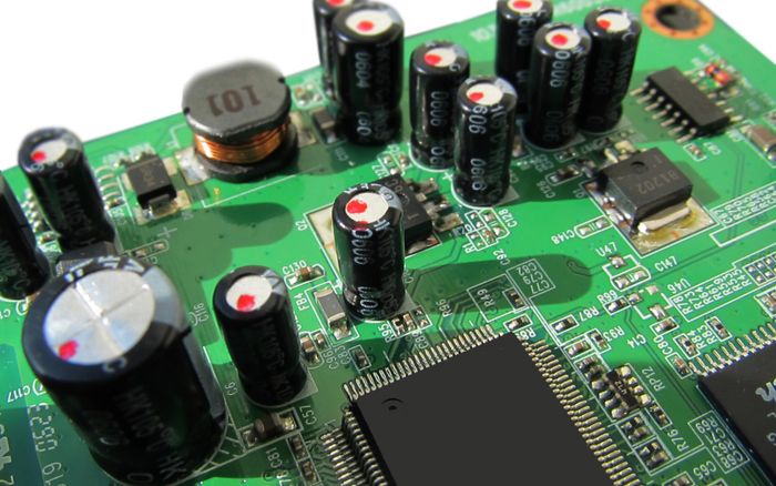 A close-up of a green circuit board with semiconductor chips.