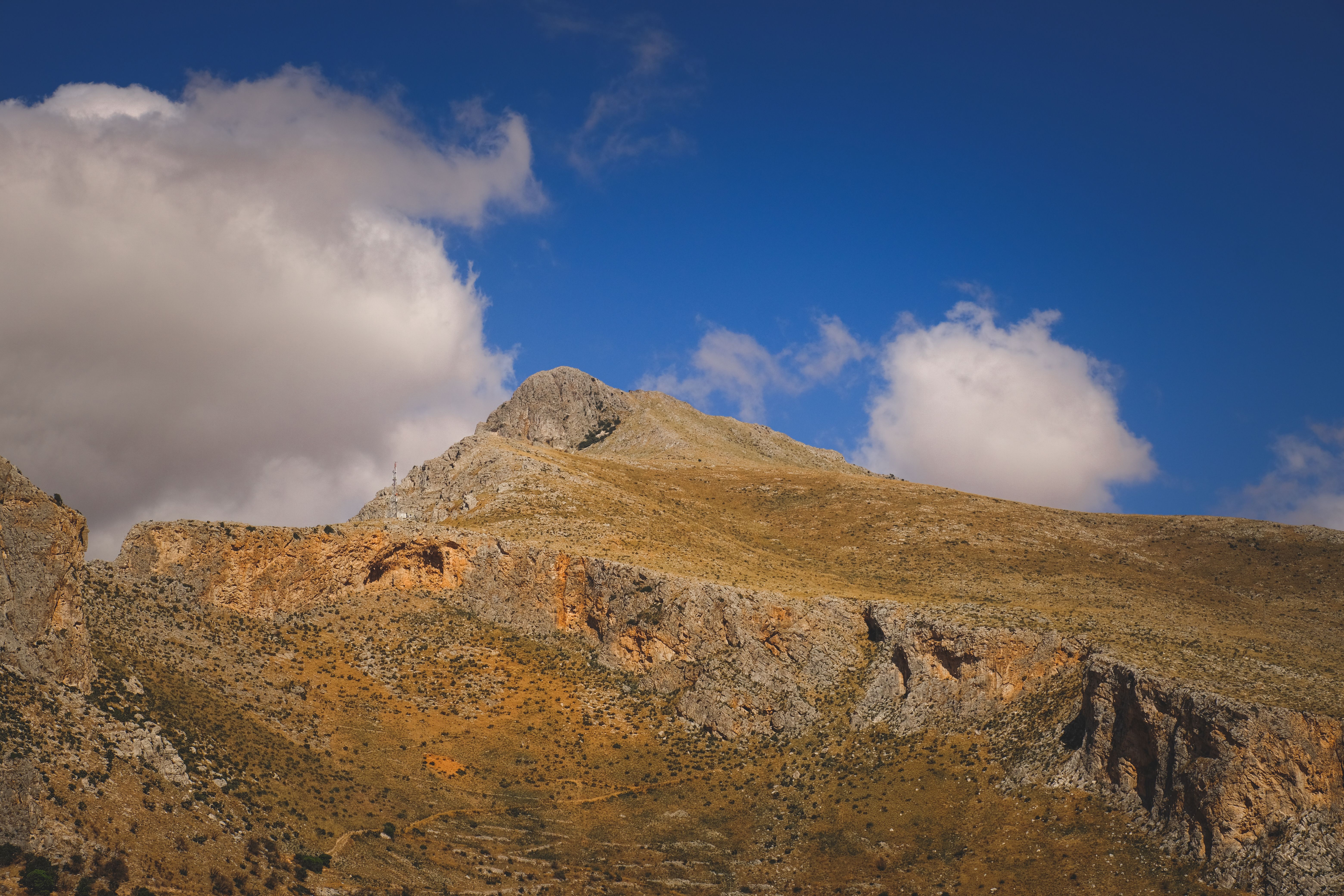 A mountain with a blue sky and clouds · Free Stock Photo