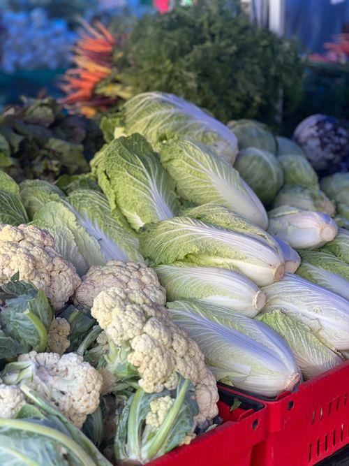 Free Abundant fresh vegetables including cabbage, cauliflower, and leafy greens at a farmer's market. Stock Photo
