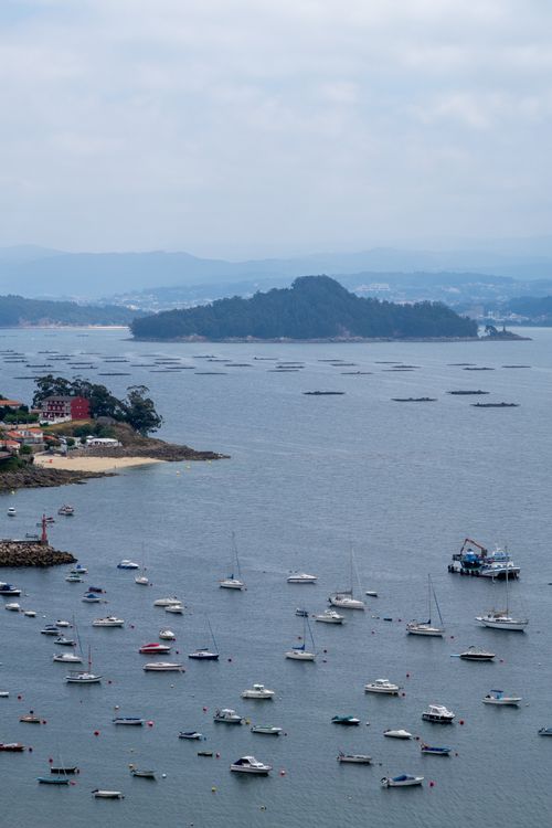 Free A beautiful aerial view of boats in a harbor with distant islands and cloudy skies. Stock Photo
