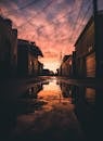 在日落时分，宁静的城市小巷中，水坑里的倒影捕捉到了宁静而大气的氛围