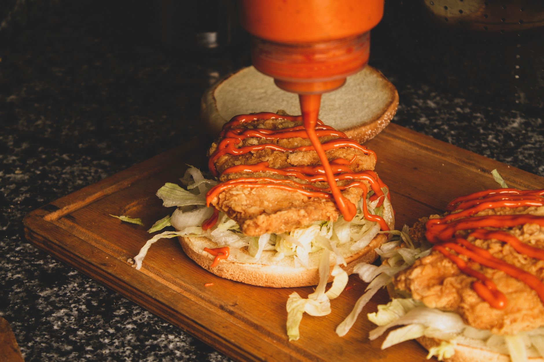 Homemade chicken burger patty being cooked on a grill