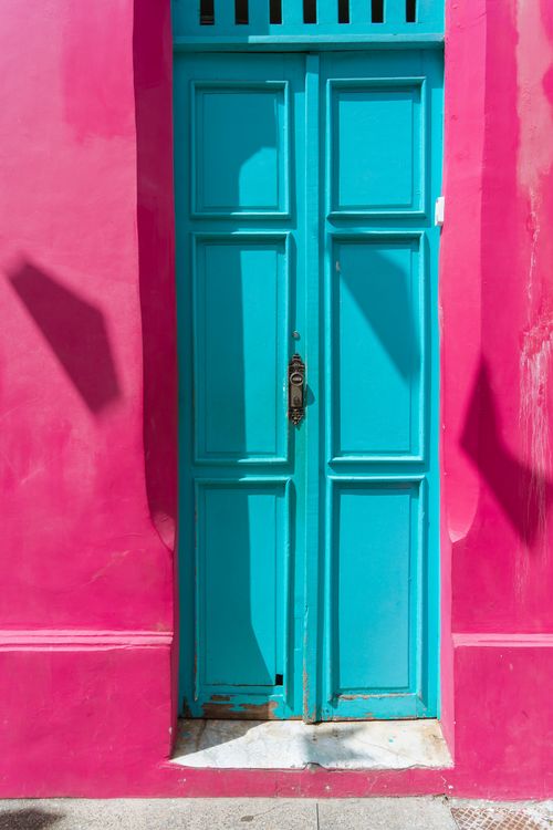Free A vintage blue door set in a vibrant pink wall, captured in a vertical composition. Stock Photo