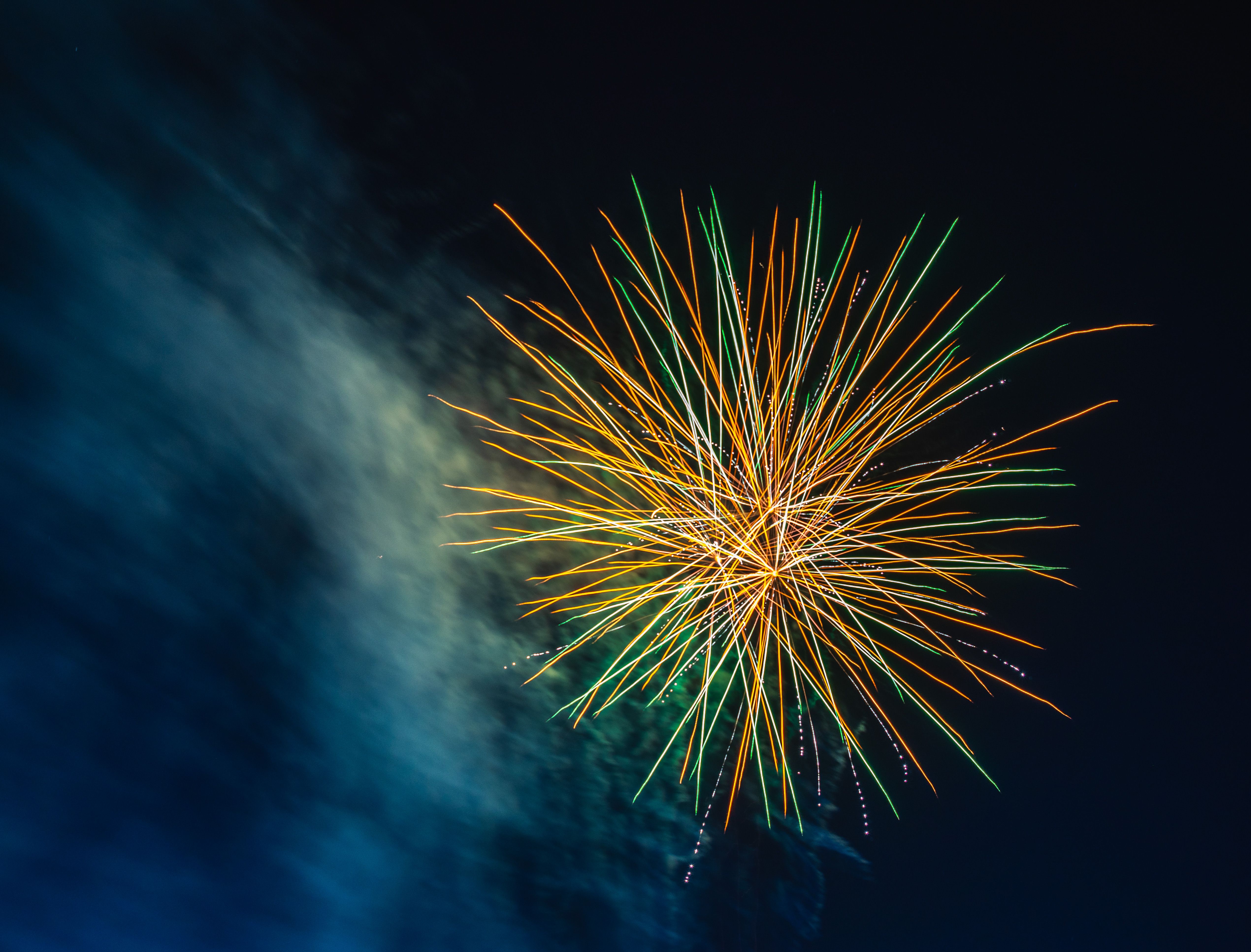 A colorful explosion of fireworks brightens the dark night sky, creating a festive atmosphere.