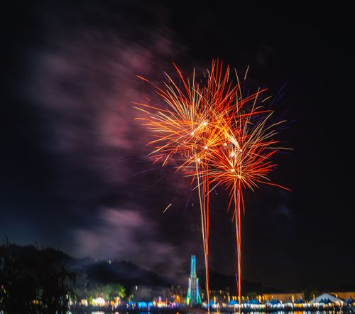 Free Colorful fireworks light up the night sky with vibrant displays over a cityscape. Stock Photo