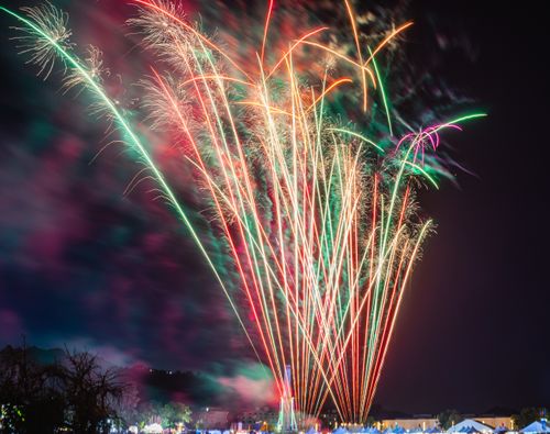 Free Spectacular fireworks light up the night sky over an urban landscape, creating a festive atmosphere. Stock Photo