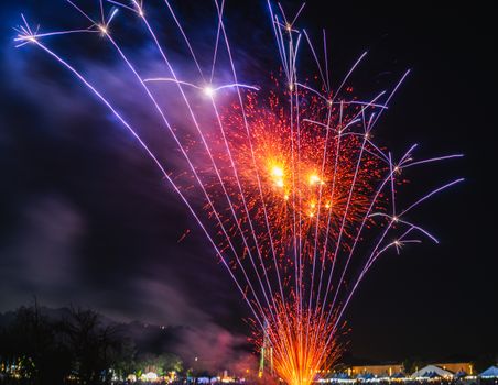 Spectacular fireworks illuminate the night sky over an urban setting, capturing the essence of celebration.