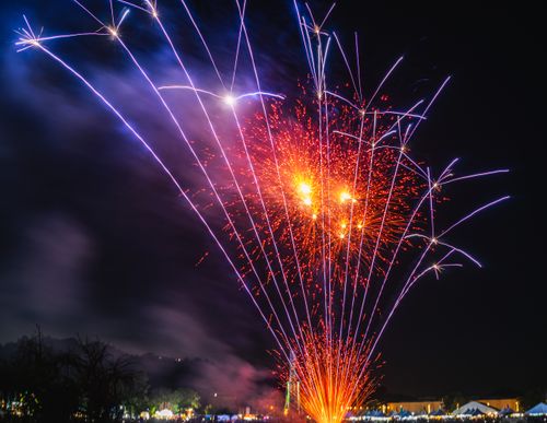 Free Spectacular fireworks illuminate the night sky over an urban setting, capturing the essence of celebration. Stock Photo