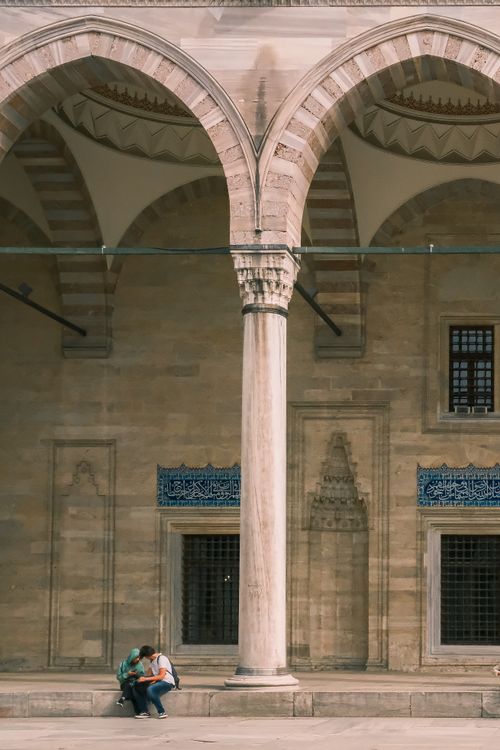 Free People sitting under the arches of Suleymaniye Mosque in Istanbul, Turkey. Stock Photo
