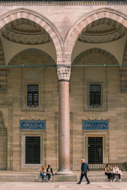 Free People in a historic courtyard with arches and columns in daytime. Stock Photo
