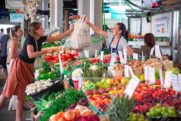 Shoppers at a colourful outdoor market stall — photo by @coldbeer on Pexels