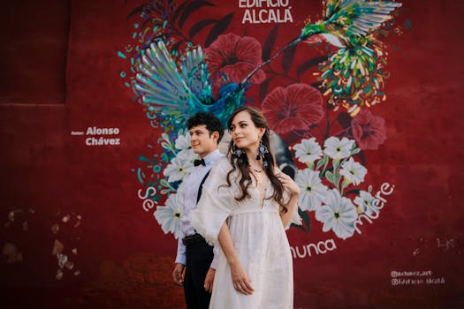 A stylish couple poses against a vibrant mural, blending fashion and street art.