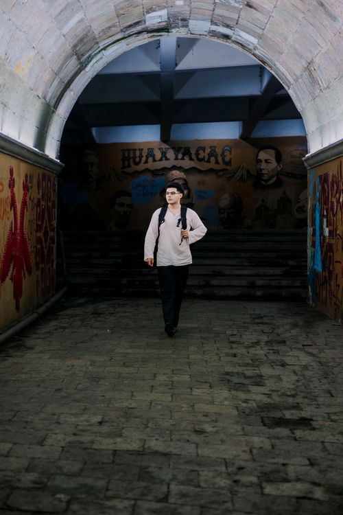Free A person walks through a colorful graffiti-lined tunnel, featuring vibrant mural art. Stock Photo
