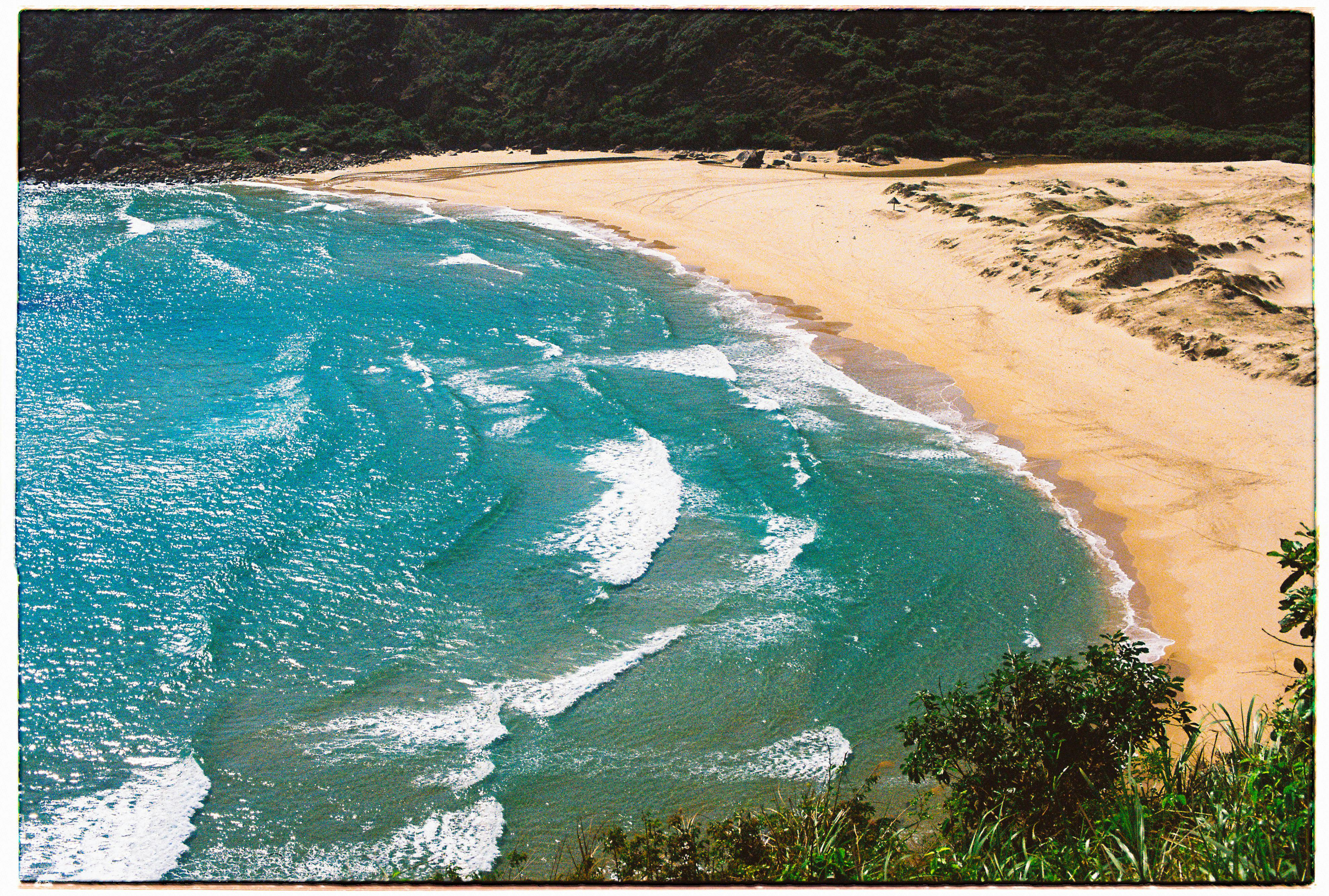 Stunning aerial view of a tropical beach with turquoise water and golden sand in Phú Yên, Vietnam.