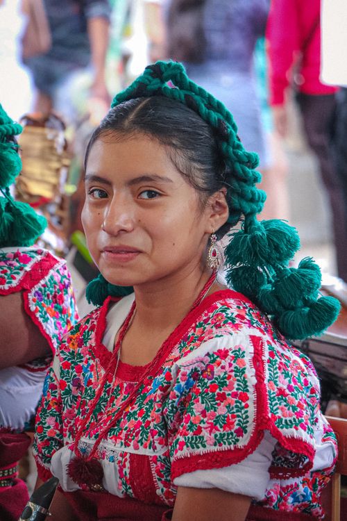 Free Young woman in vibrant traditional attire smiles at a cultural festival. Stock Photo