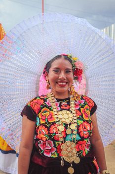 Vibrant portrait of a woman in traditional attire featuring colorful embroidery and ornate accessories.