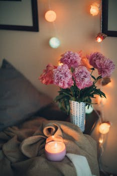 在迷人的舒适卧室角落，牡丹花、蜡烛和环境照明共同营造出温暖的氛围