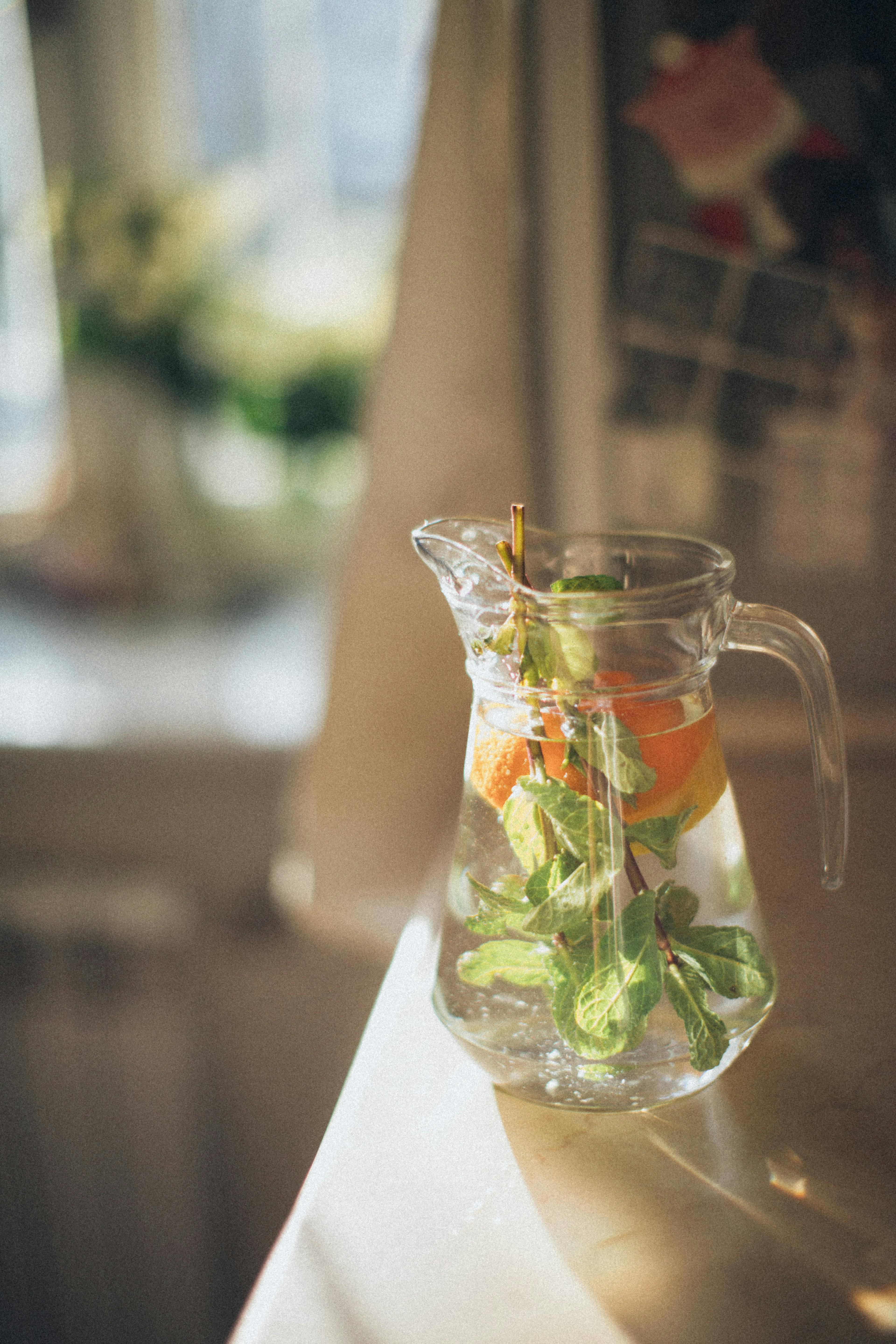 clear glass pitcher with leaves and fruit infuse