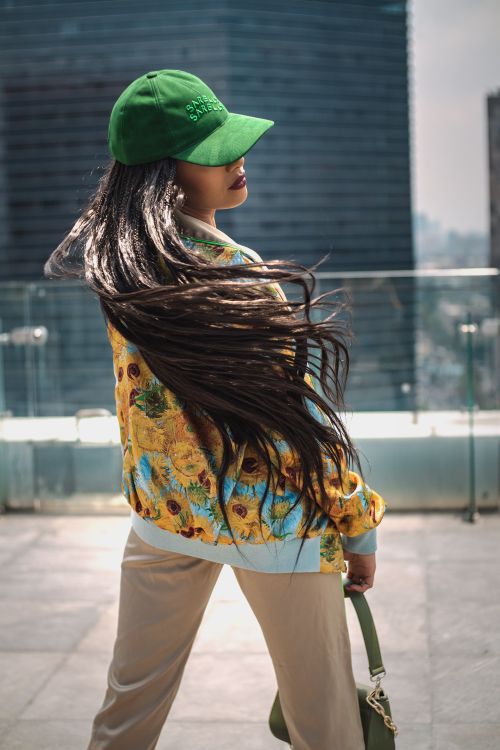 Free Stylish woman with long hair in vibrant jacket posing on a rooftop in Ciudad de México. Stock Photo