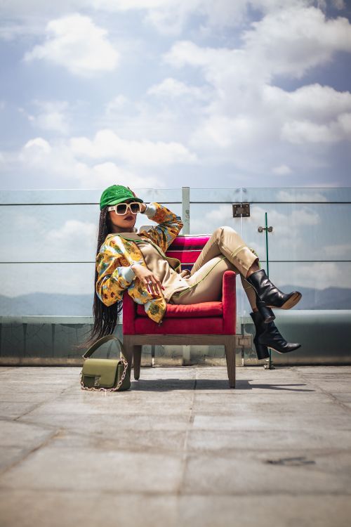 Free Fashionable African American woman in a vibrant outfit posing on a rooftop in Mexico City. Stock Photo