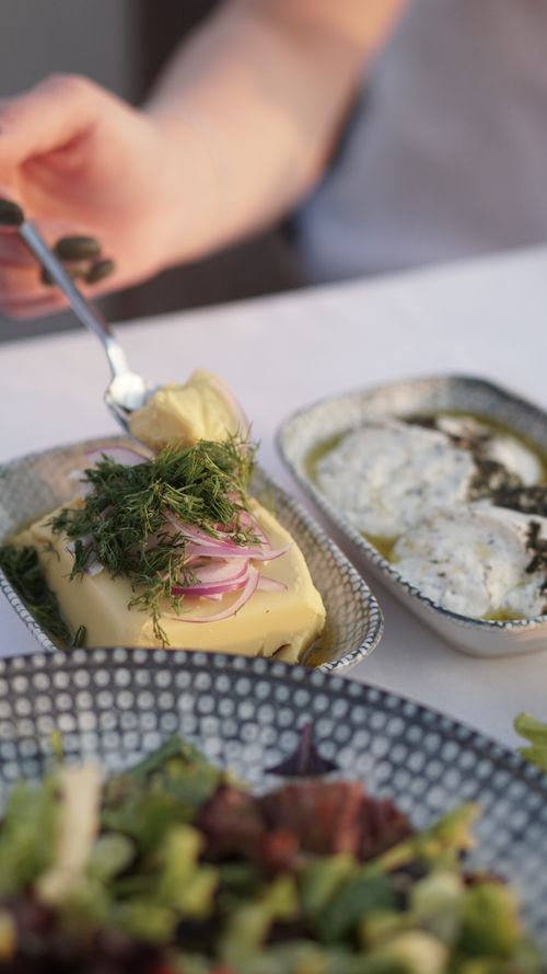 Free Butter garnished with herbs and onions on a table, perfect for a fresh breakfast setup. Stock Photo
