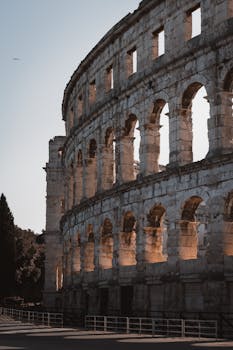 Capture the historic beauty of the ancient Roman amphitheater in Pula at sunset.