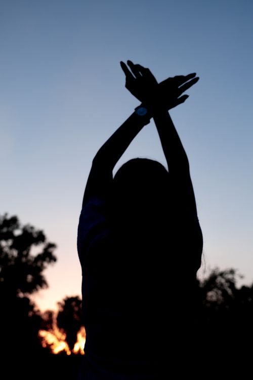 Silhouette of Woman Standing with Arms Raised · Free Stock Photo