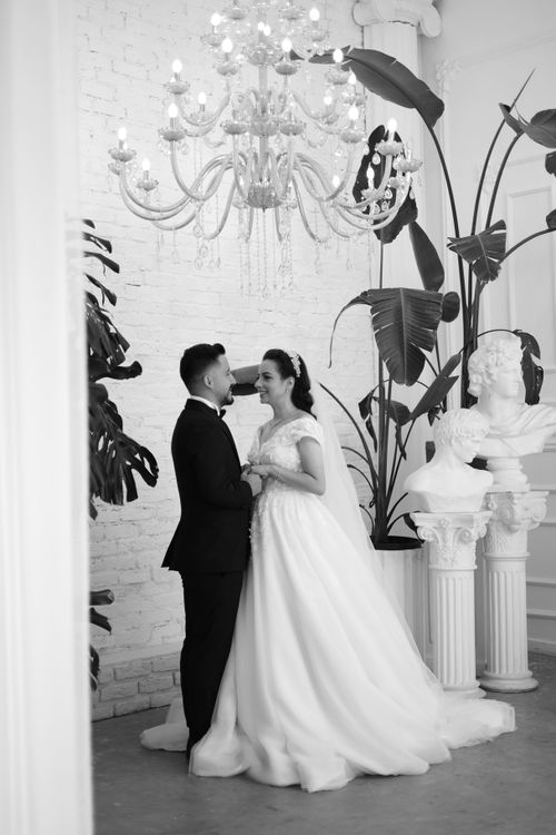 Free A romantic black and white portrait of a couple on their wedding day in an elegant setting. Stock Photo