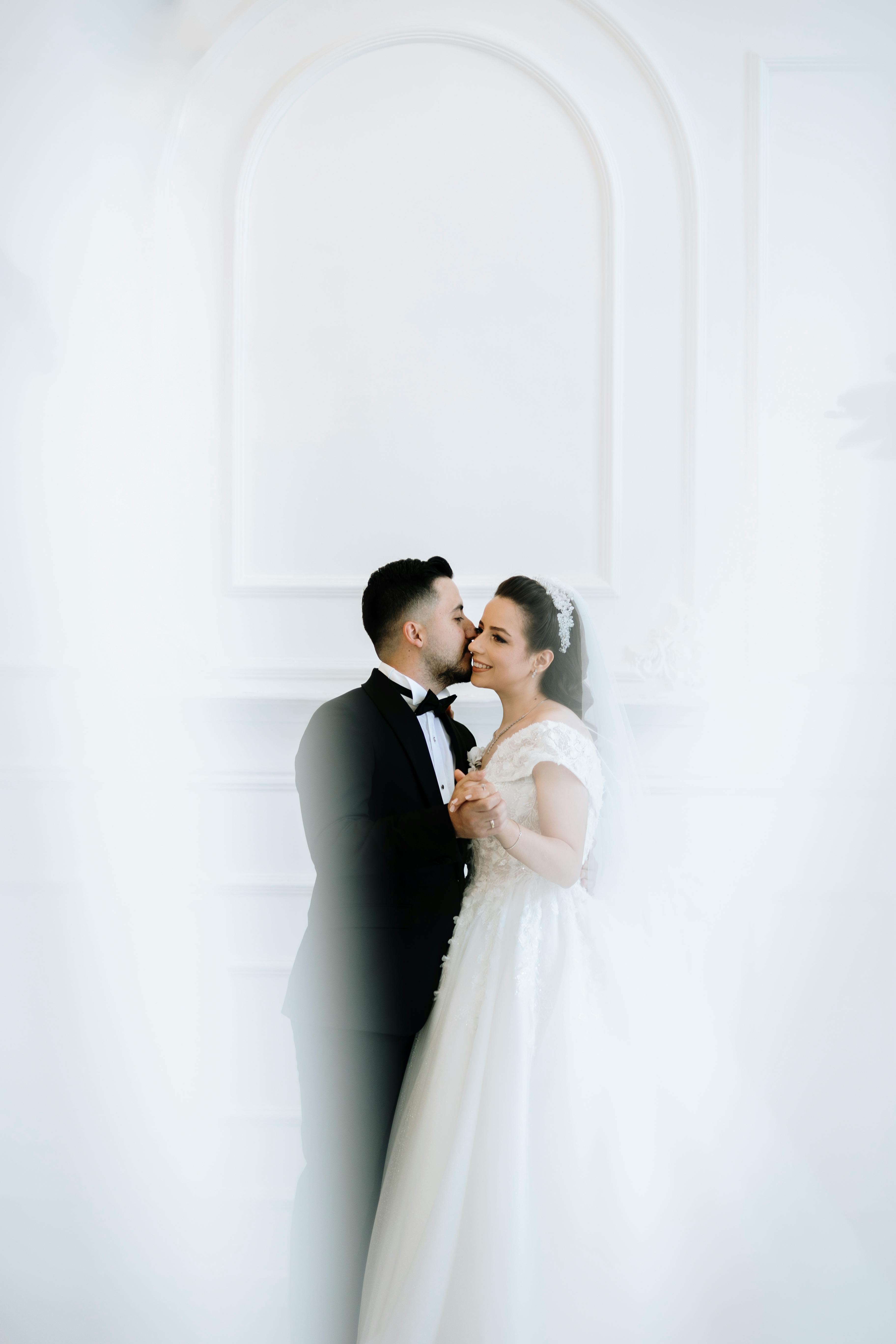 the groom kissing the bride on the cheek