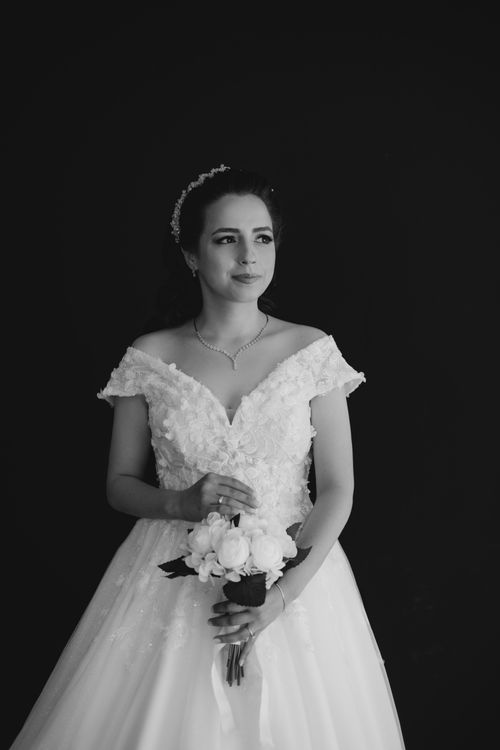 Free Classic black and white portrait of a bride holding a bouquet, exuding timeless beauty and tradition. Stock Photo