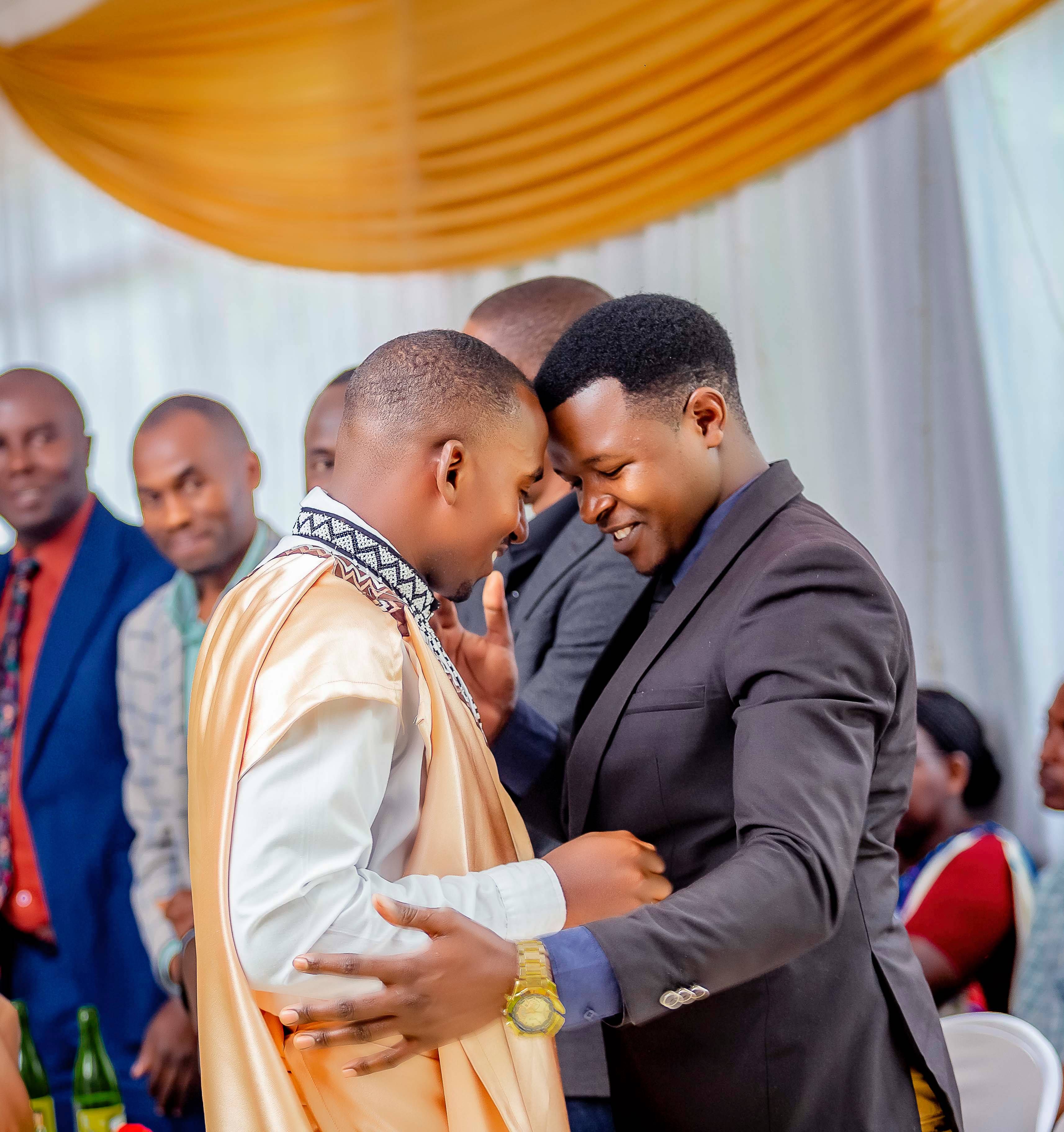A heartfelt embrace at a vibrant indoor celebration, capturing friendship and happiness.